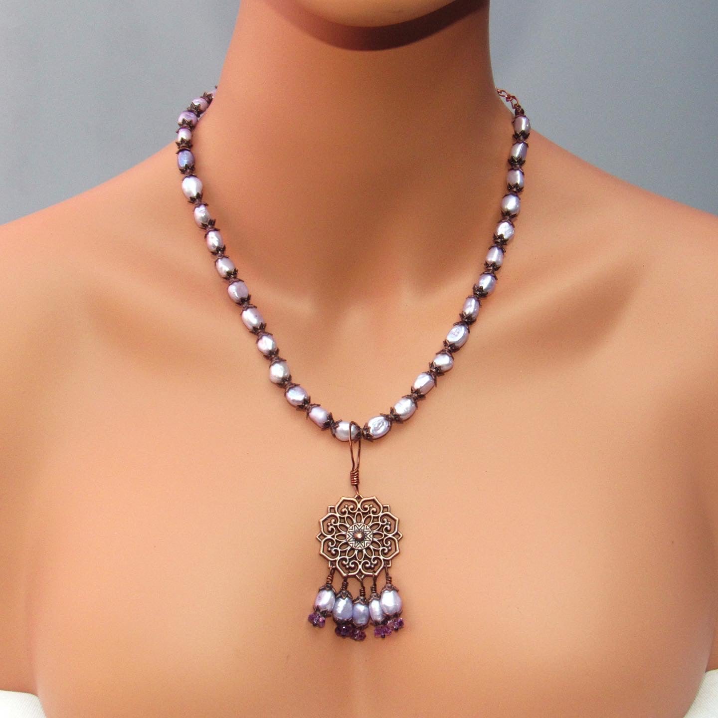 Purple freshwater pearls, amethyst gemstones, and copper chain and pendant design.