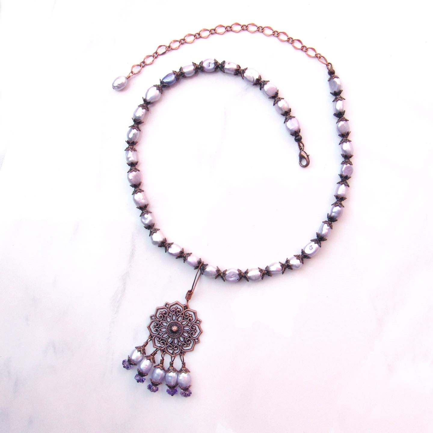 Purple freshwater pearls, amethyst gemstones, and copper chain and pendant design.